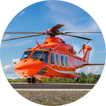An Ornge Leonardo AW139 helicopter on a helipad with a blue sky in the background